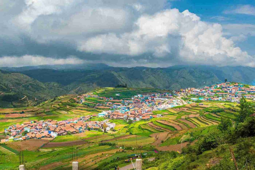 Scenic view of Kodaikanal village with terraced fields, colorful houses and green hills, one of the 11 best places to visit in april in india