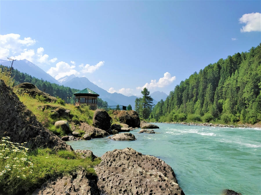 "A peaceful view of the Lidder River flowing through Pahalgam, Kashmir, recognized as one of the 13 best places to visit in August in India 2026."