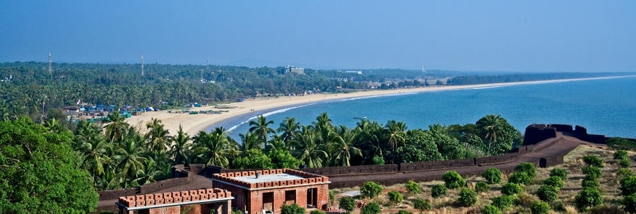 A panoramic view of the historic Bekal Fort stone walls overlooking a sandy curved beach and palm trees, featured as one of the 21 best places to visit in south.
