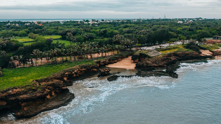 Aerial view of the rocky cliffs and palm-lined shores of Diu, a serene coastal destination among the 19 best places to visit in December 2026.