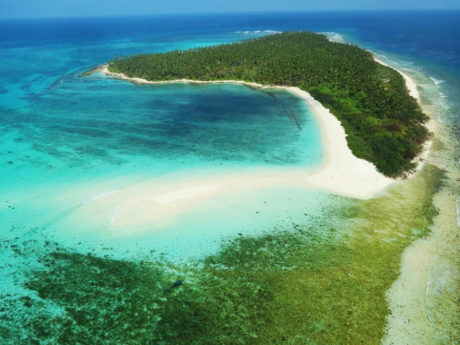 Aerial view of the turquoise lagoons and white sand beaches of Lakshadweep, one of the 19 best places to visit in December 2026.
