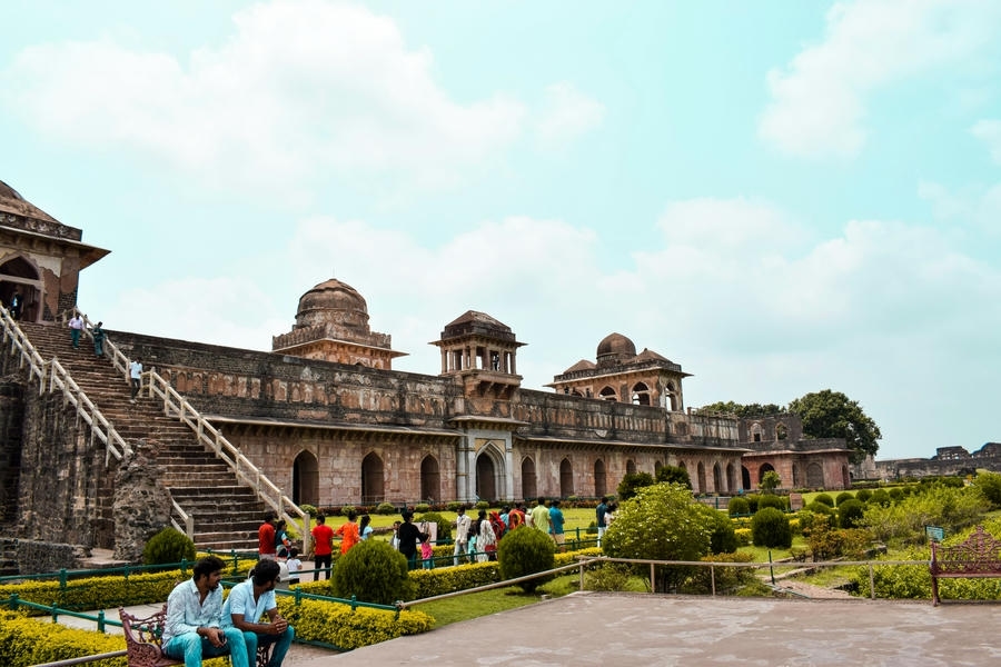 Tourists exploring the historic stone architecture and domes of Mandu, Madhya Pradesh, featured in the 15 best places to visit in November in India 2026.