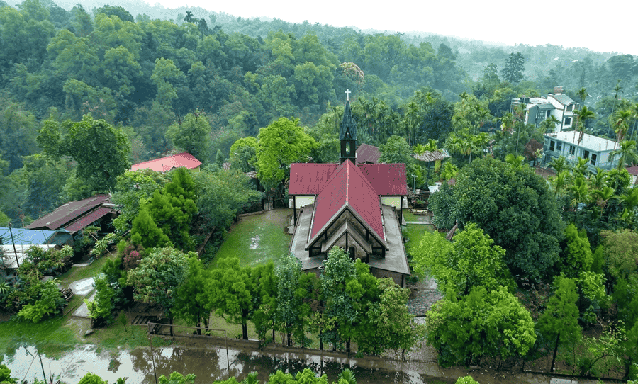 Aerial view of the Church of the Epiphany surrounded by lush greenery in Mawlynnong, Meghalaya, one of the 15 best places to visit in November in India 2026.