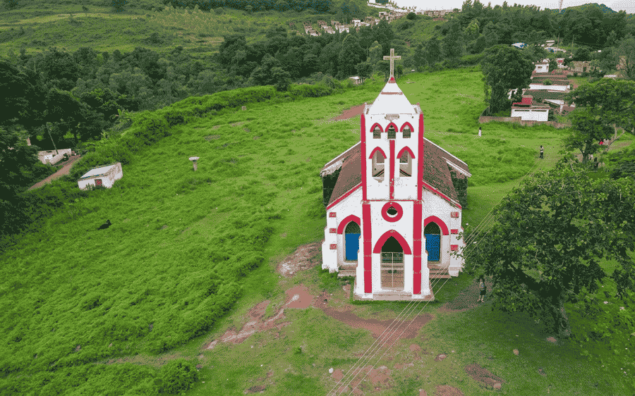 Aerial view of historic red and white Sunkarimetta Church atop a green hill in Araku Valley, showcasing hidden hill stations in South India 2026.