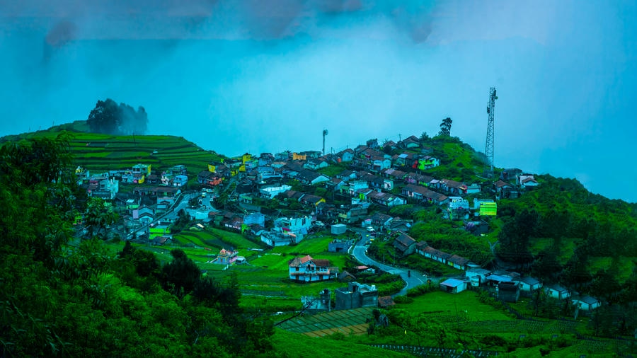 Panoramic view of Poombarai village step farms enveloped in mist, showcasing hidden hill stations in South India 2026.