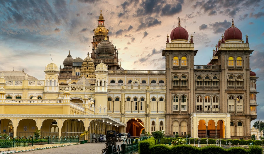 Exterior view of the grand Mysore Palace illuminated at dusk, leading the list of 19 best places to visit in Mysore.