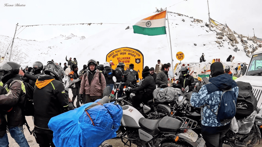 A photo of a group of travelers in a snowy mountain pass, representing a day trip to Nubra Valley via Khardung La from a Leh Ladakh Itinerary.