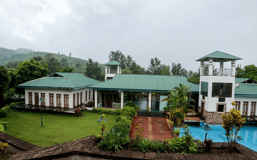Looking down at a peaceful resort with green roofs and a pool in Ananthagiri Hills, listed as a top spot among the best places to visit in Araku Valley.