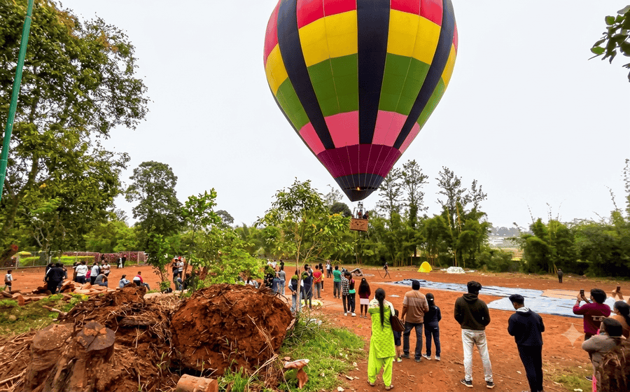 Visitors gathering at Padmapuram Gardens to watch a scenic hot air balloon ride, featured as a top destination among the best places to visit in Araku Valley.