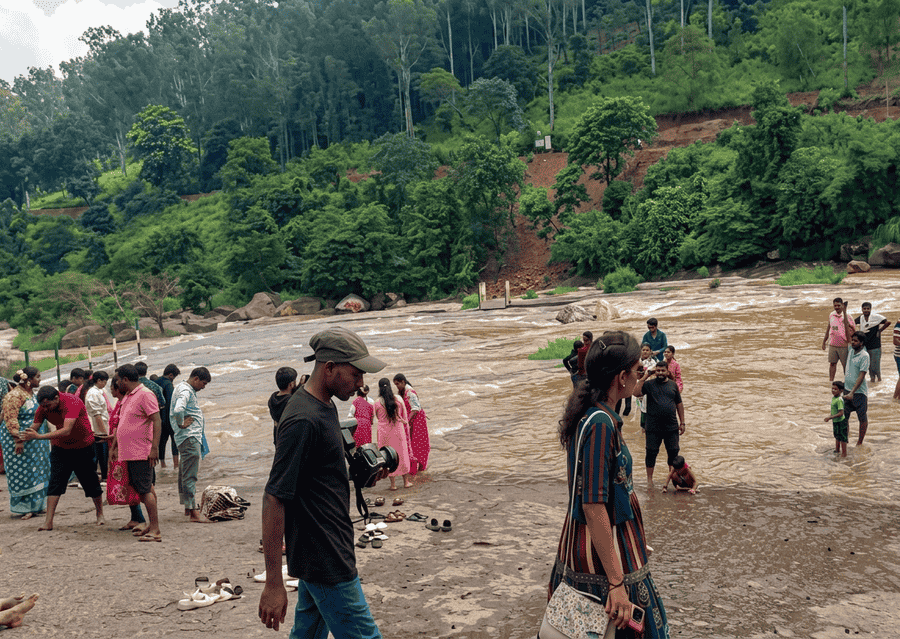 A scenic view of visitors gathering near the natural water slide at Chaparai Water Cascade, featured among the top best places to visit Araku Valley.