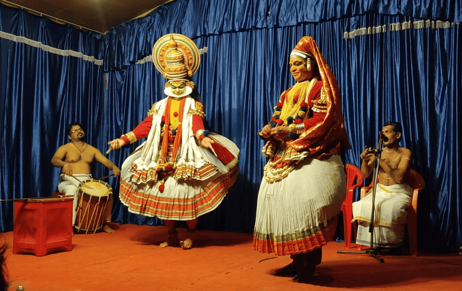 Kathakali dancers performing in full traditional attire with live drummers stage-side at Mudra Cultural Centre, featured as one of the best places to visit in Thekkady.