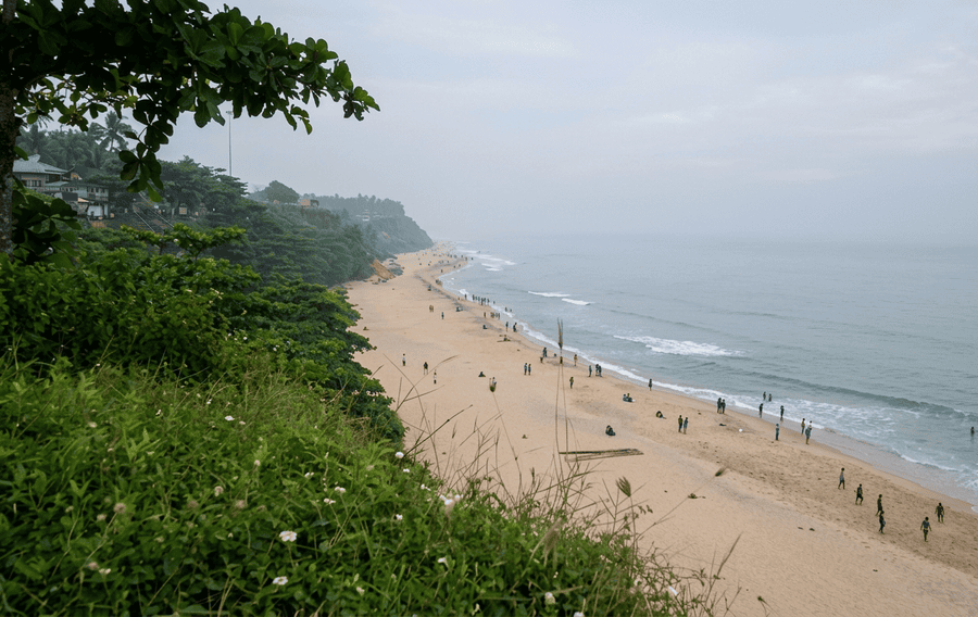 Varkala Beach seen from above the cliffs, featuring the sandy shore and gentle waves. It is considered one of the best places to visit in Varkala.