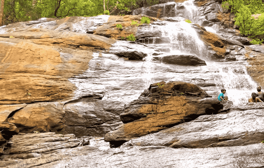 A high-resolution, clear view of Kiliyur Falls cascading down the large, wet rock formations, one of the best places to visit in Yercaud for nature lovers.