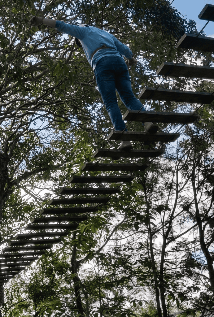 A visitor navigating a high-altitude aerial obstacle course at Grange TreeTop Adventure, an exciting destination and one of the best places to visit in Yercaud.