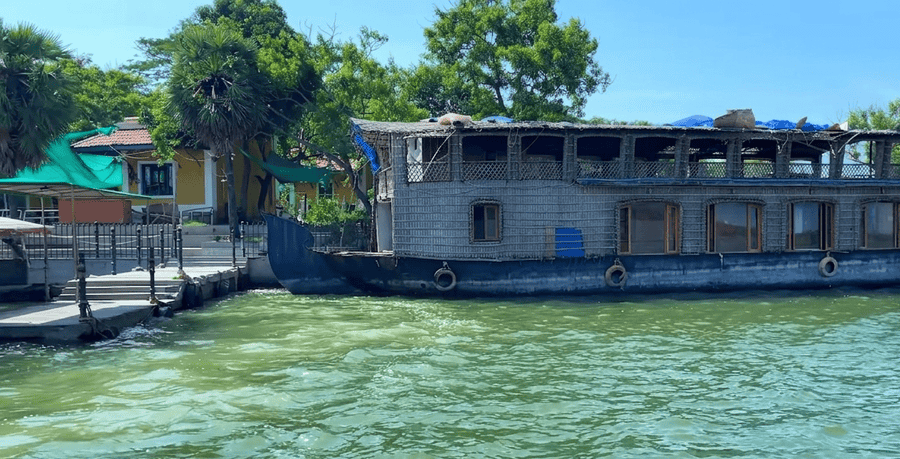 A Kerala-style houseboat is moored at Paradise Beach, Pondicherry, which is known as one of the best places to visit Pondicherry for unique coastal and water-based experiences.