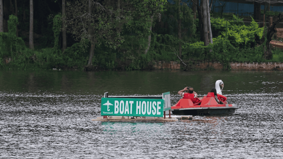 The lush green trees and floating Boat House marker at Yercaud Lake, a popular location featured among the best places to visit in Yercaud.